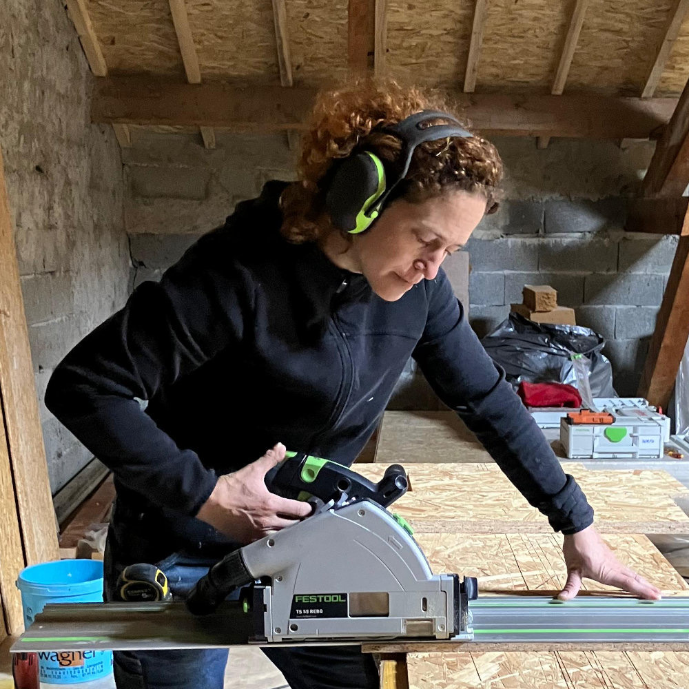 Gaëlle Germain découpant un panneau de bois dans son atelier
